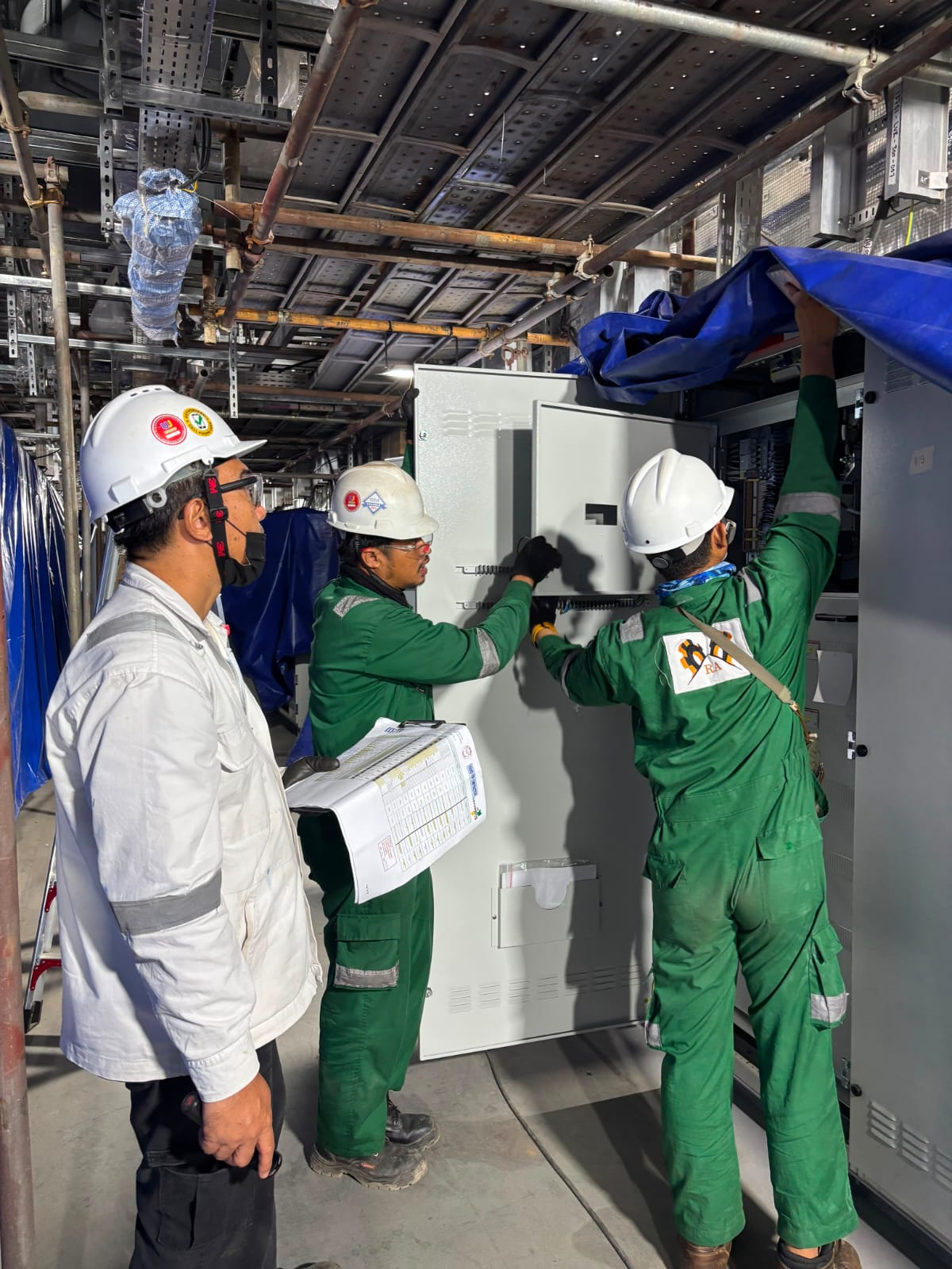 Technicians installing E&I control panel in E-House module