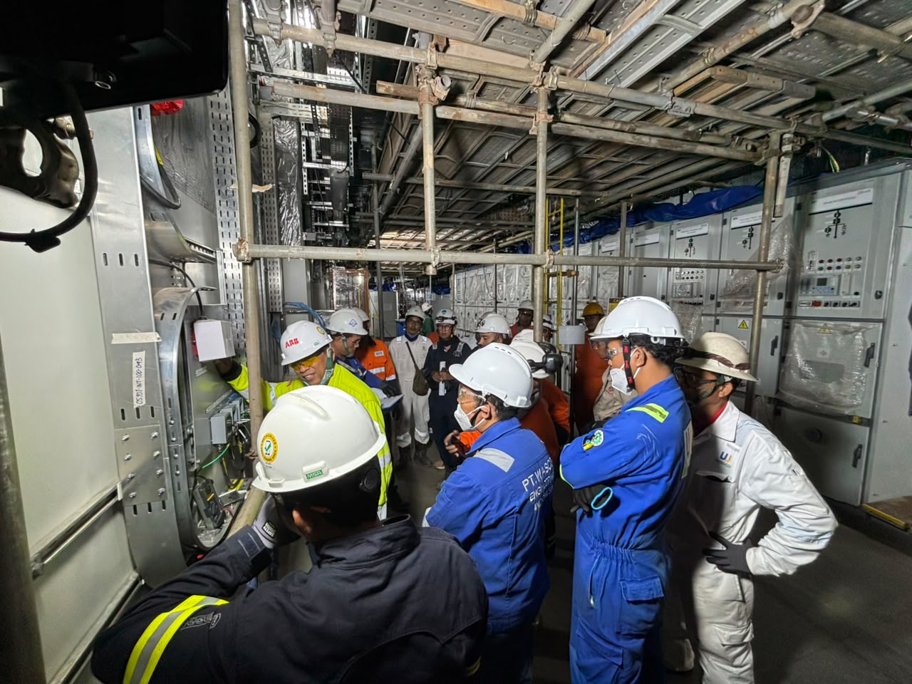 Multi-disciplinary crew reviewing switchgear installation